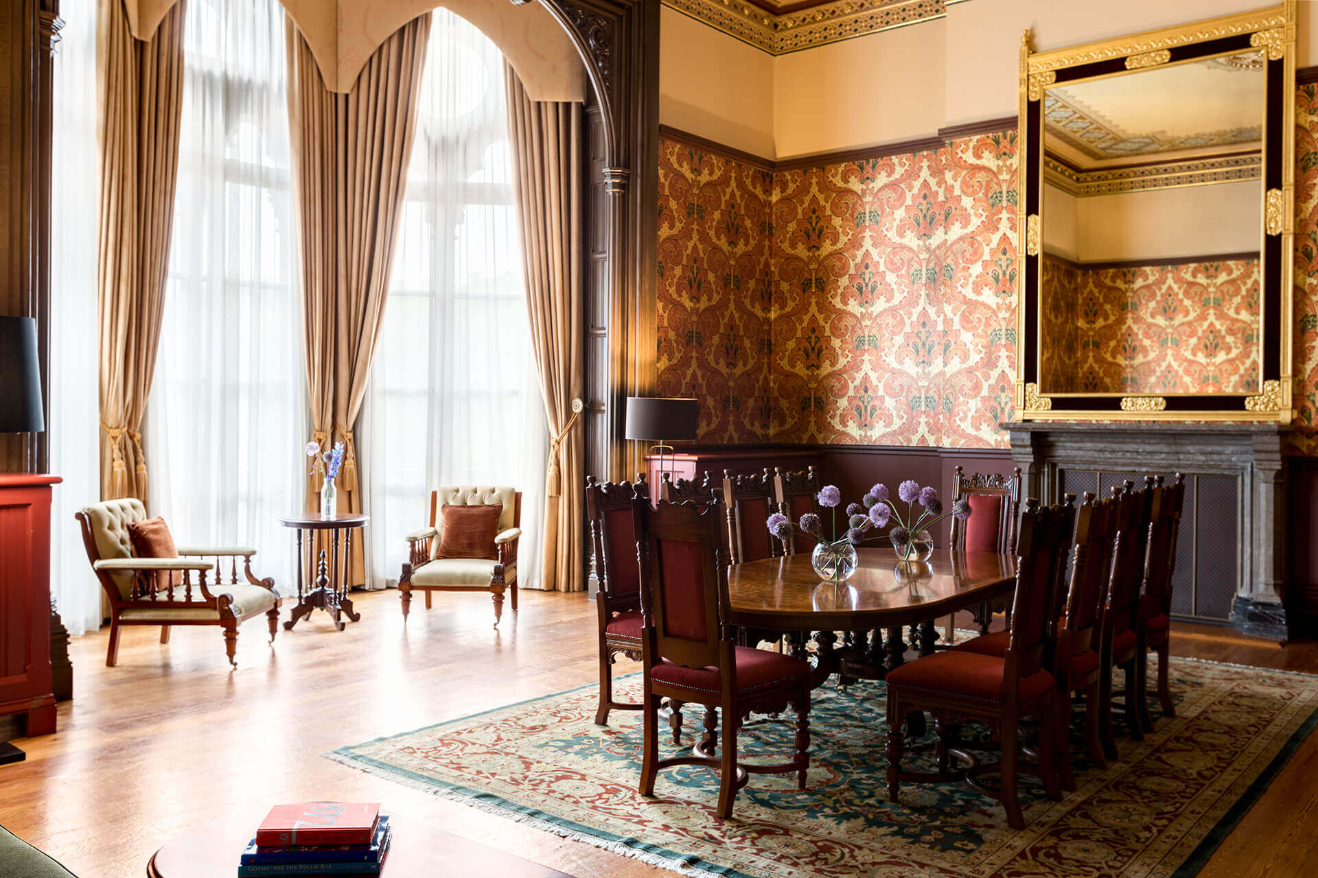 General view featuring armchairs, dining table and a bay window inside the George Gilbert Scott Suite at the 5 star London hotel St. Pancras London. London 5 star hotel suite.